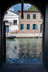A view of a quiet Venetian canal and historic buildings seen through the entrance of the Tanzania National Pavilion during the 61st International Art Exhibition – La Biennale di Venezia.