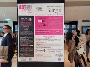 Official information board for Art Shopping Paris 2023 at the Carrousel du Louvre, Paris, France, displaying the event dates, venue, schedule, and exhibition program.