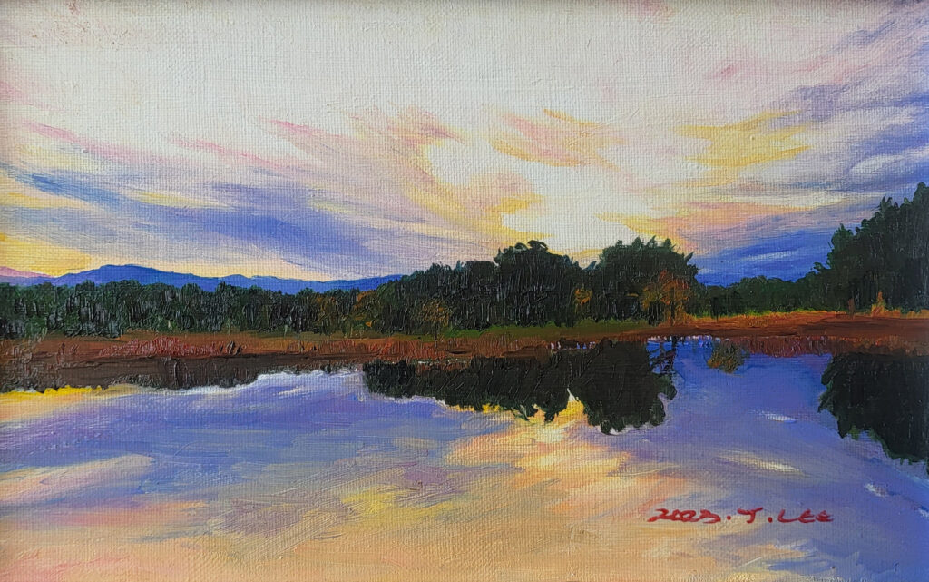 A tranquil lakeside at sunset reflecting pastel clouds and a quiet forest, capturing the peaceful atmosphere of an early spring evening.